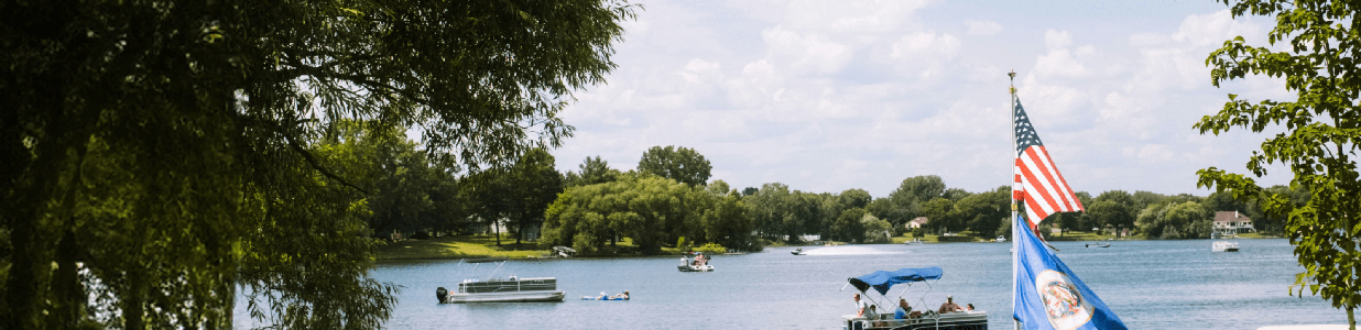 Lake with pontoon boats and jet skis in the water