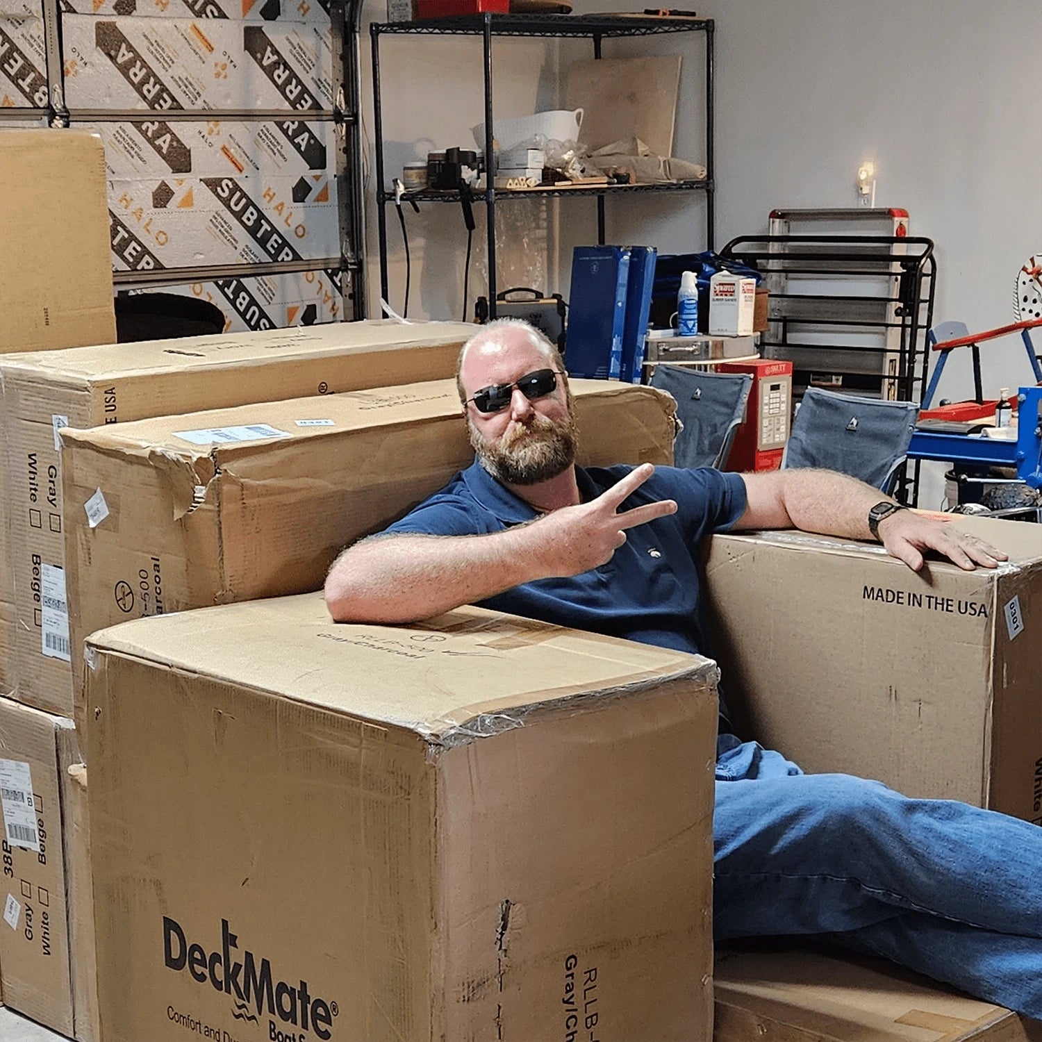 Cool guy sitting on deckmate furniture boxes in a garage