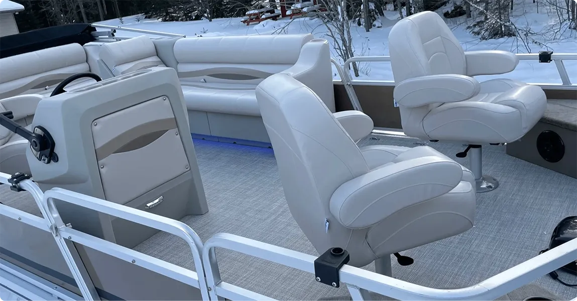 Pontoon boat with premium ivory and beige furniture with bench seats, lean backs, console, and helm chairs