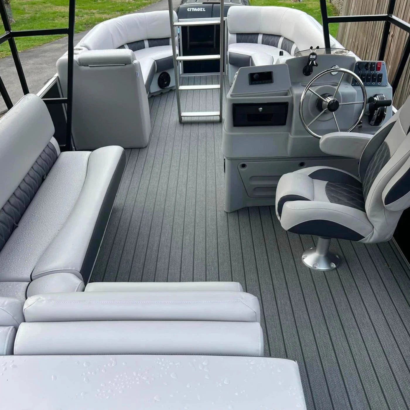 Pontoon boat with luxury furniture including bench seats, corner seats, lean back seats, a helm chair, and console