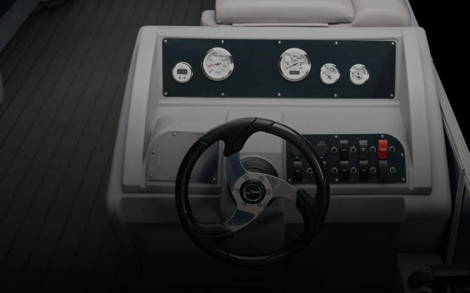 Pontoon boat console with carbon fiber panels, gauges, switches, and steering wheel