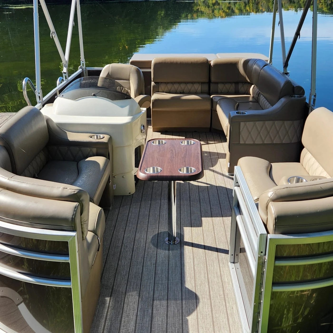 Pontoon boat with luxury furniture bench seats, corner seats, helm chair, and console