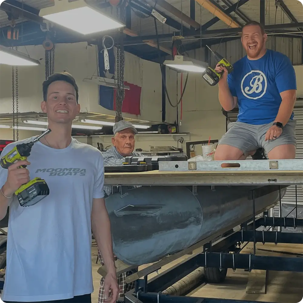 3 Men working on a pontoon boat deck in their garage