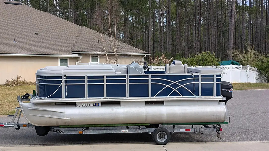 Pontoon boat on a trailer with navy fencing