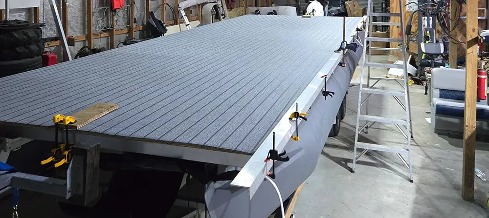 Pontoon boat being worked on attaching vinyl furniture