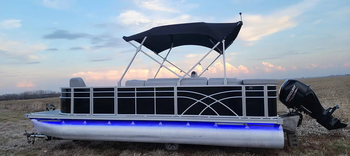Pontoon boat on a trailer with luxury furniture and a black fence with a sundeck